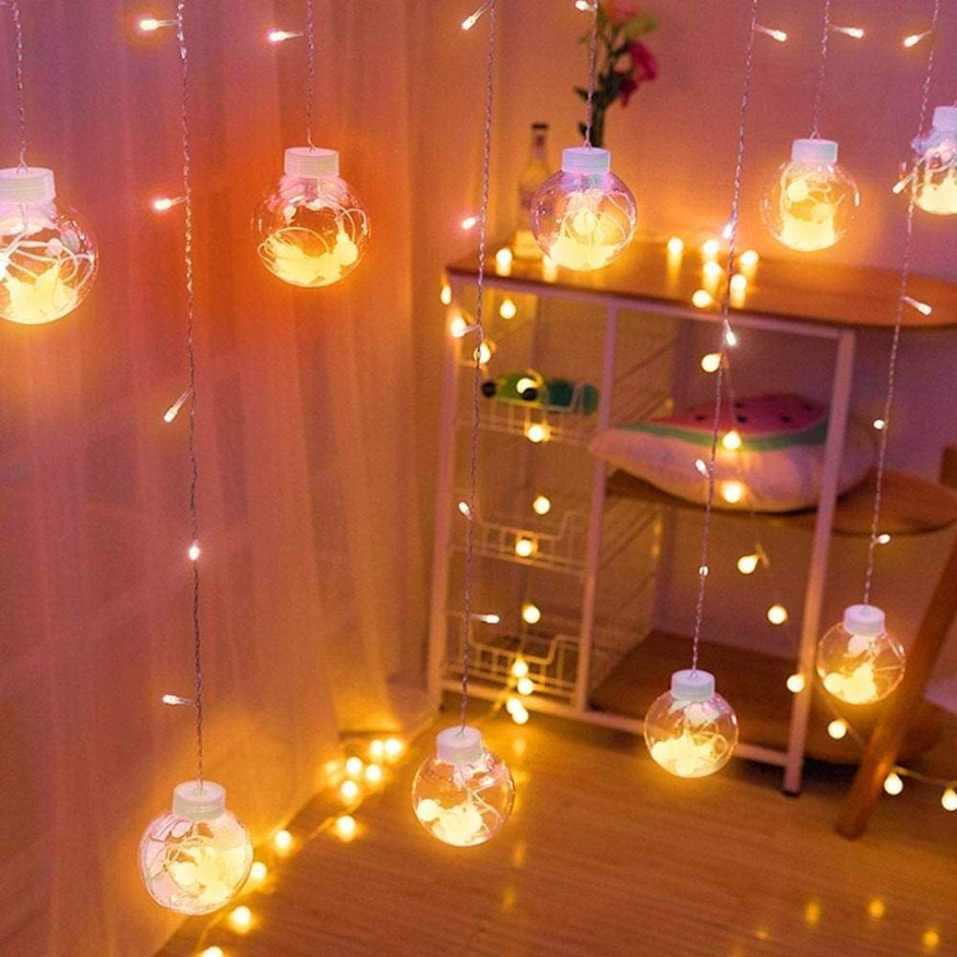 String lights with glowing bulbs hanging in a room.